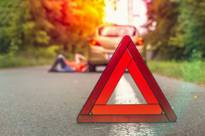 Driver lying under the broken car