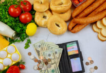 Produce with wallet and money on white table.