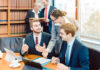 Lawyers in their law firm working on computer with books