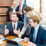 Lawyers in their law firm working on computer with books