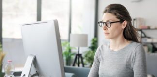 Professional woman sitting at desk and connecting with her computer