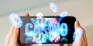 In a man's hand a smartphone with playing neon cards, chips, dice