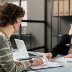 Young woman with neck injury filling documents