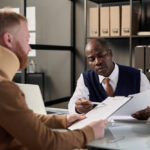 Insurance broker helping man with neck brace