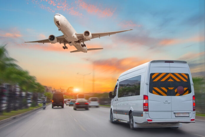 Mini bus drives along the highway among other cars in the evening in the sunset sky