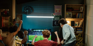 Happy Fans Watching Soccer Match on television