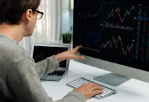 Investors pointing interesting stock exchange on pc with laptop