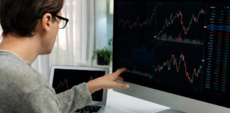 Investors pointing interesting stock exchange on pc with laptop