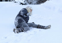 A woman slips on the winter road.