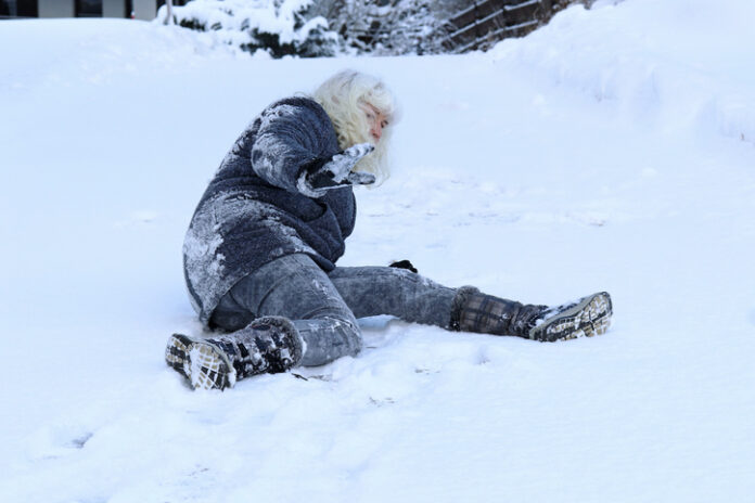 A woman slips on the winter road.