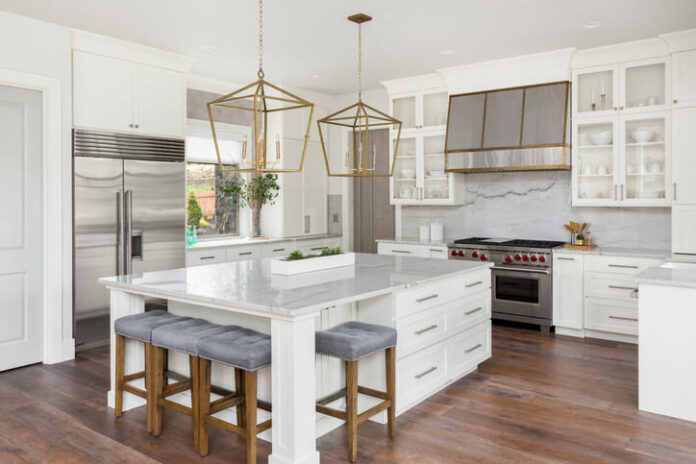 Beautiful kitchen in new luxury home with island, pendant lights, and hardwood floors