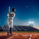 Baseball player at professional baseball stadium in evening during a game.