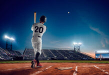 Baseball player at professional baseball stadium in evening during a game.