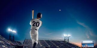 Baseball player at professional baseball stadium in evening during a game.