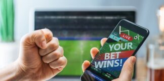 Lucky man celebrating victory after making bets using gambling mobile application on his phone.
