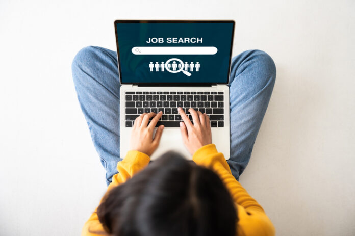 Top view of woman sitting on floor and using laptop job search.