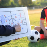 Coach training a tactic for football player