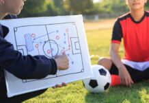 Coach training a tactic for football player