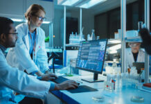 Female Research Scientist with Bioengineer Working on a Personal Computer with Screen Showing Gene Analysis Software User Interface.