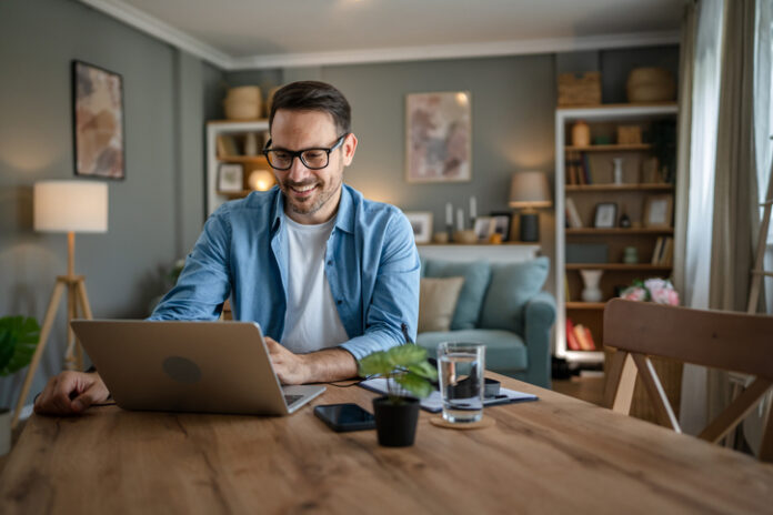 One man adult caucasian work on laptop at home happy smile