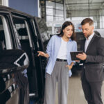 Lady Buyer Standing In Luxury Automobile Dealership Store.