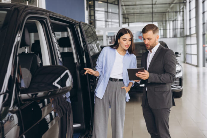 Lady Buyer Standing In Luxury Automobile Dealership Store.