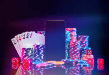 Brightly colored poker chips and playing cards arranged near a smartphone