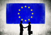 Two Business Person Shaking Hands with the European Union Flag