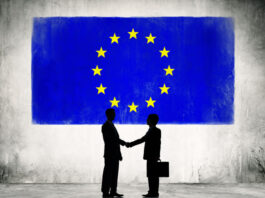 Two Business Person Shaking Hands with the European Union Flag