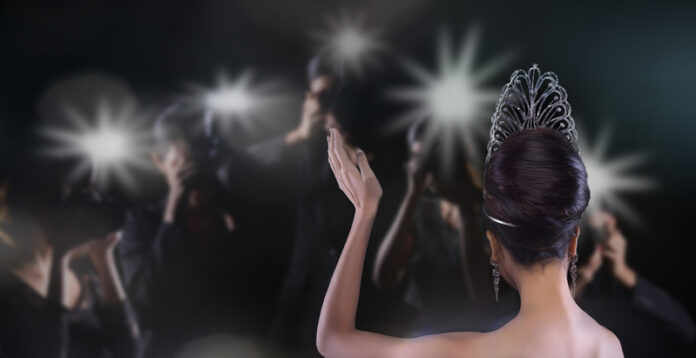 Back side view of Miss Pageant beauty contest with Silver Diamond Crown wave hand to many Photographers