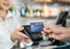 Close up shot of customer hand using dummy credit card for payment to waitress at cashier in cafe restauran