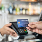 Close up shot of customer hand using dummy credit card for payment to waitress at cashier in cafe restauran