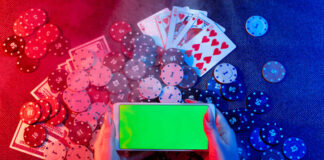 Playing cards, betting Chips and a smartphone with a copy space in women's hands