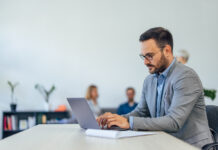 Serious-looking businessman using a modern technology, a laptop.