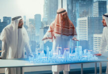 Business Developers in Traditional Clothes Discuss Investing Opportunities Based on Holographic Augmented Reality 3D City Model in Their Modern Office in a Skyscraper.