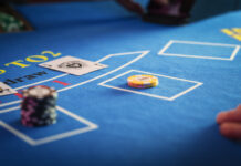 Anonymous Croupier Dealing Playing Cards on a Blackjack Table with Bet Chips in Place.