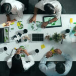 Top down view of business team discussing about using clean energy and sustainable investment at meeting table