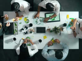 Top down view of business team discussing about using clean energy and sustainable investment at meeting table