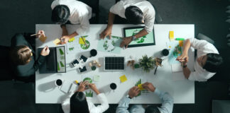 Top down view of business team discussing about using clean energy and sustainable investment at meeting table