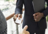 Businessman holding business card giving to another