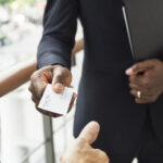 Businessman holding business card giving to another