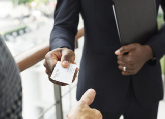 Businessman holding business card giving to another