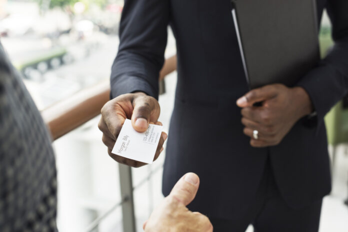 Businessman holding business card giving to another