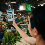 Woman holding up a smart phone in a market