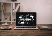 laptop with marketing icons, smartphone and cup of coffee on wooden table