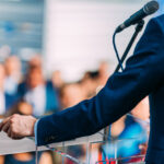 Politician speaking to the crowd from stage