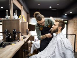 Client during beard shaving in barber shop