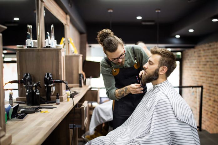 Client during beard shaving in barber shop