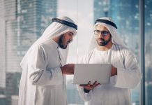 Two Successful Muslim Businessmen in White Traditional Outfit Standing in Office Meeting