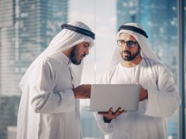 Two Successful Muslim Businessmen in White Traditional Outfit Standing in Office Meeting